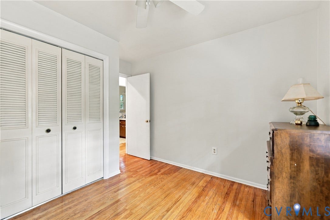 Hardwood flooring, painted walls, white louvered closet doors, and a ceiling fan