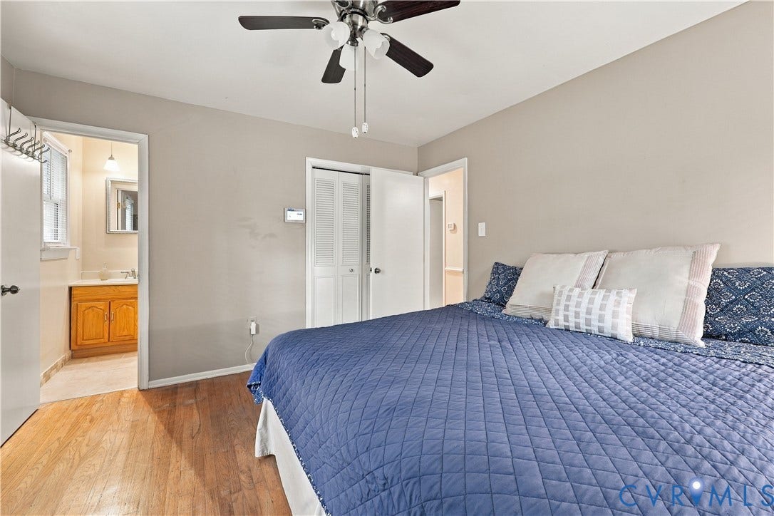 Hardwood flooring throughout, neutral wall paint, and a ceiling fan with light fixture