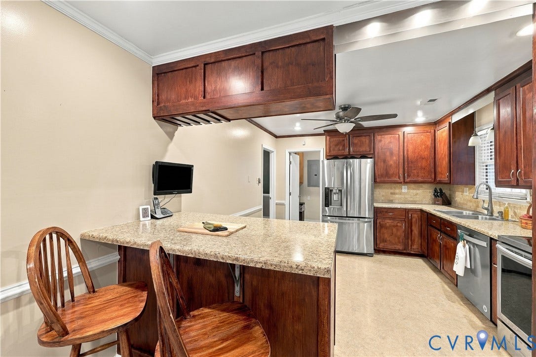 Kitchen featuring wood cabinetry, stainless steel appliances, a stone countertop, a tile backsplash, and recessed lighting