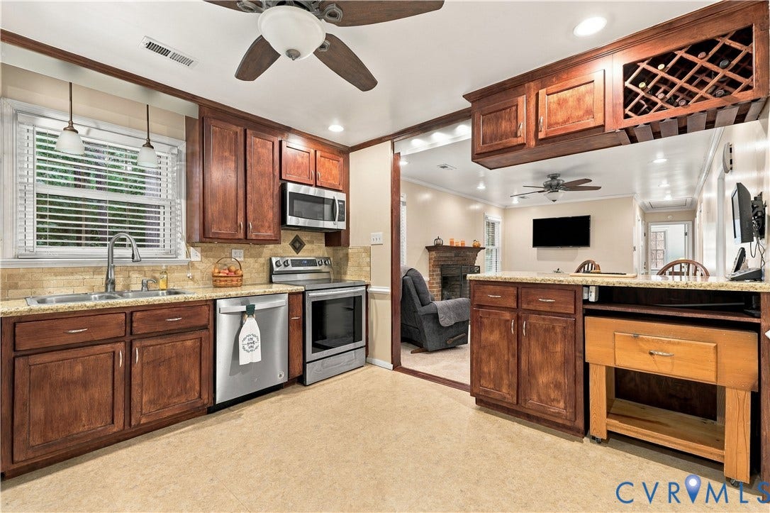 Kitchen featuring wood cabinetry, stainless steel appliances, and a built-in wine rack