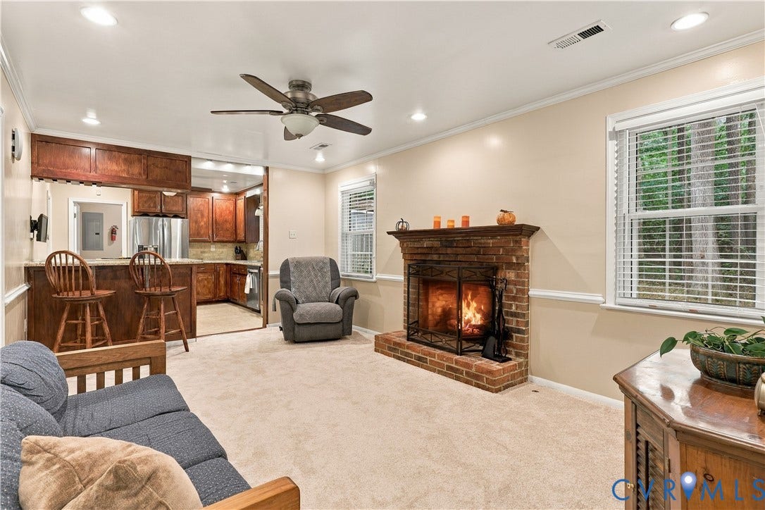 Brick fireplace with a metal screen, wood mantel, and hearth