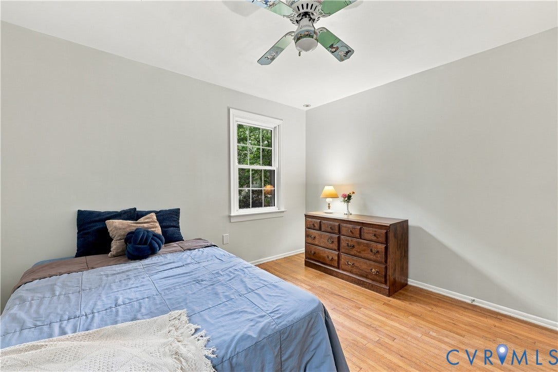 Hardwood flooring, painted walls, window with trim, and a ceiling fan
