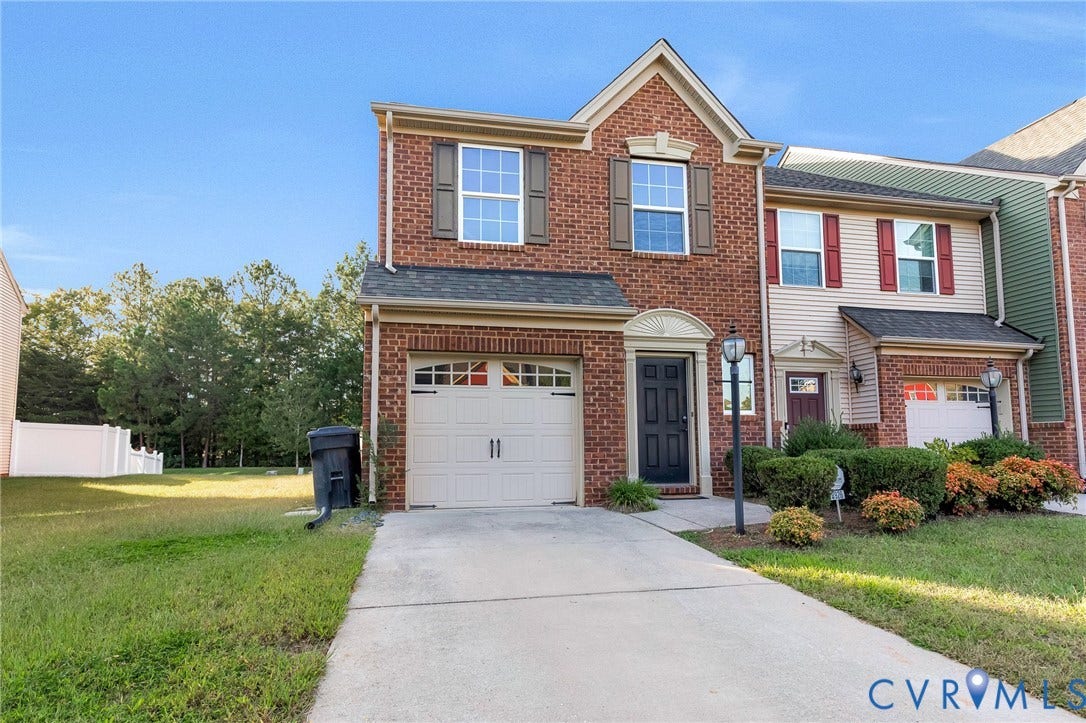 8926 Ringview Drive, Mechanicsville, VA 23116 Brick facade with contrasting shutters, attached garage, concrete driveway, front entry with decorative trim, and an adjacent landscaped area