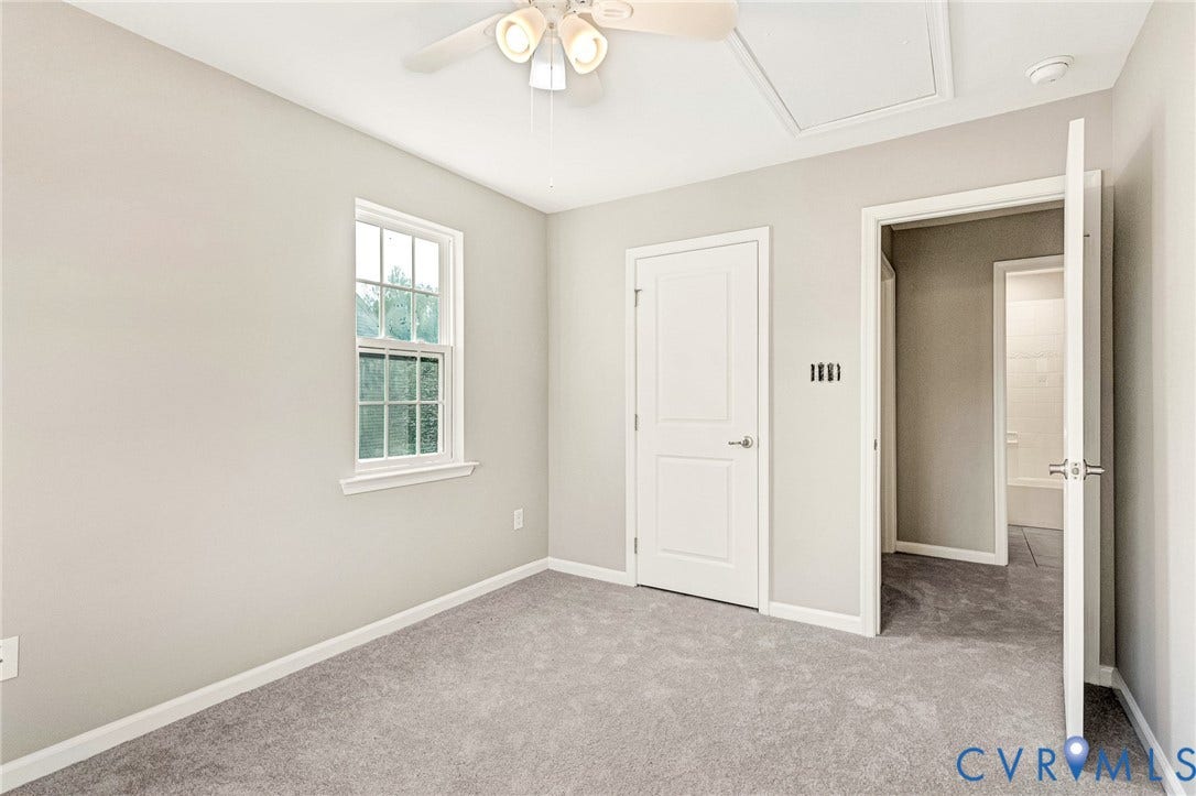 8926 Ringview Drive, Mechanicsville, VA 23116 Window with grid inserts, light gray wall paint, gray carpet, white interior door, and ceiling fan with light kit