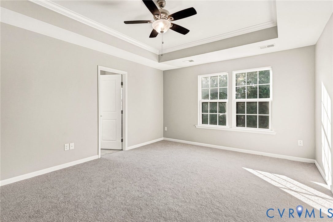 8926 Ringview Drive, Mechanicsville, VA 23116 Tray ceiling with crown molding, ceiling fan, and two multi-pane windows
