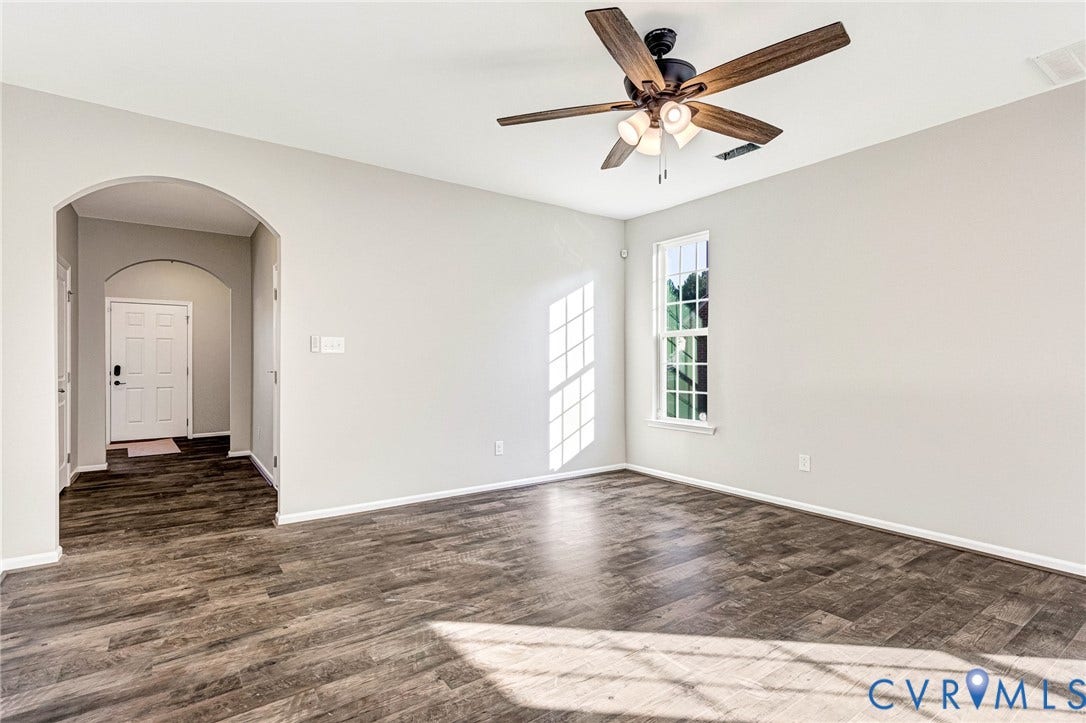 8926 Ringview Drive, Mechanicsville, VA 23116 Wood-finish flooring, neutral wall tones, arched doorway, ceiling fan with integrated lighting, and a multi-pane window