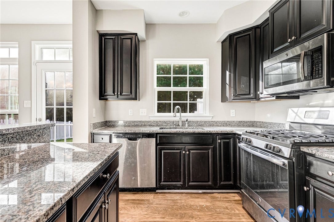 8926 Ringview Drive, Mechanicsville, VA 23116 Kitchen featuring dark wood cabinetry, light-colored granite countertops, stainless steel appliances, and wood-finish flooring