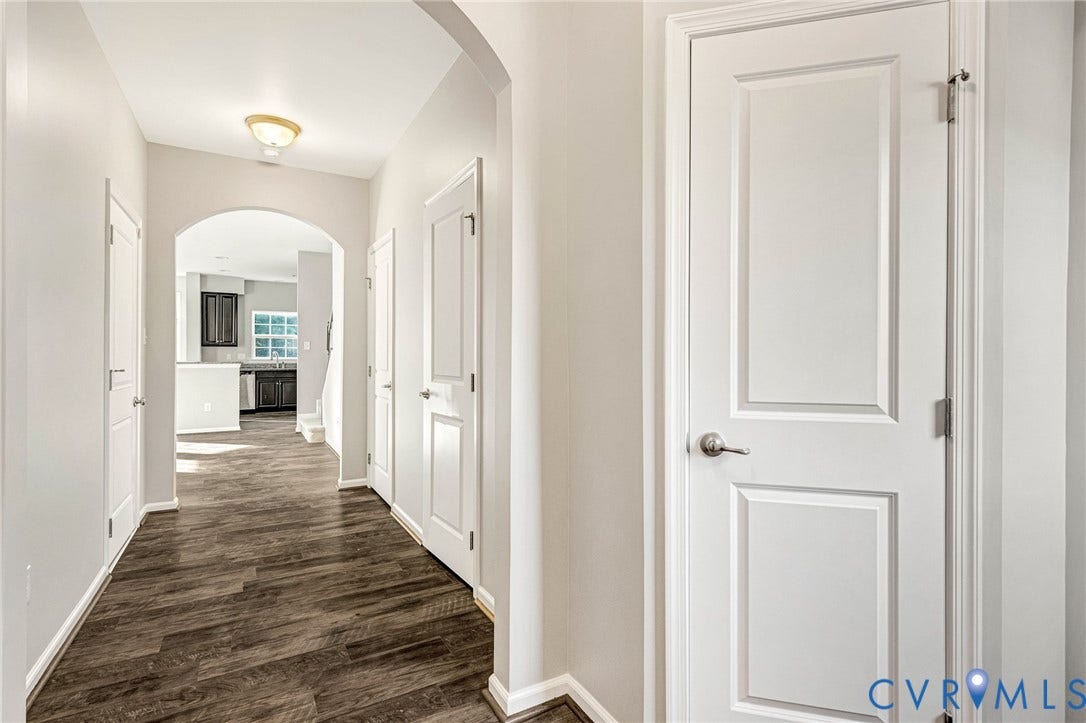 8926 Ringview Drive, Mechanicsville, VA 23116 Hallway featuring wood-finish flooring, light gray wall paint, white trim, and paneled interior doors
