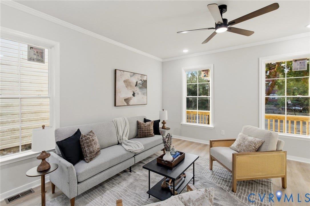 Bright living area featuring wood-finish flooring and crown molding