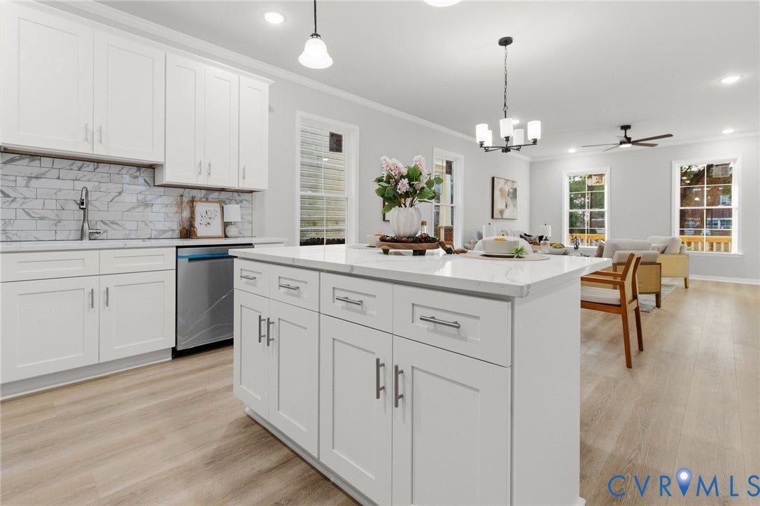 Kitchen island with white shaker cabinetry, stainless steel dishwasher, white subway tile backsplash, and light wood-finish flooring