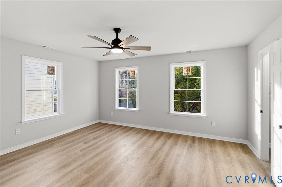 Wood-finish flooring, white painted walls, and a ceiling fan with integrated lighting