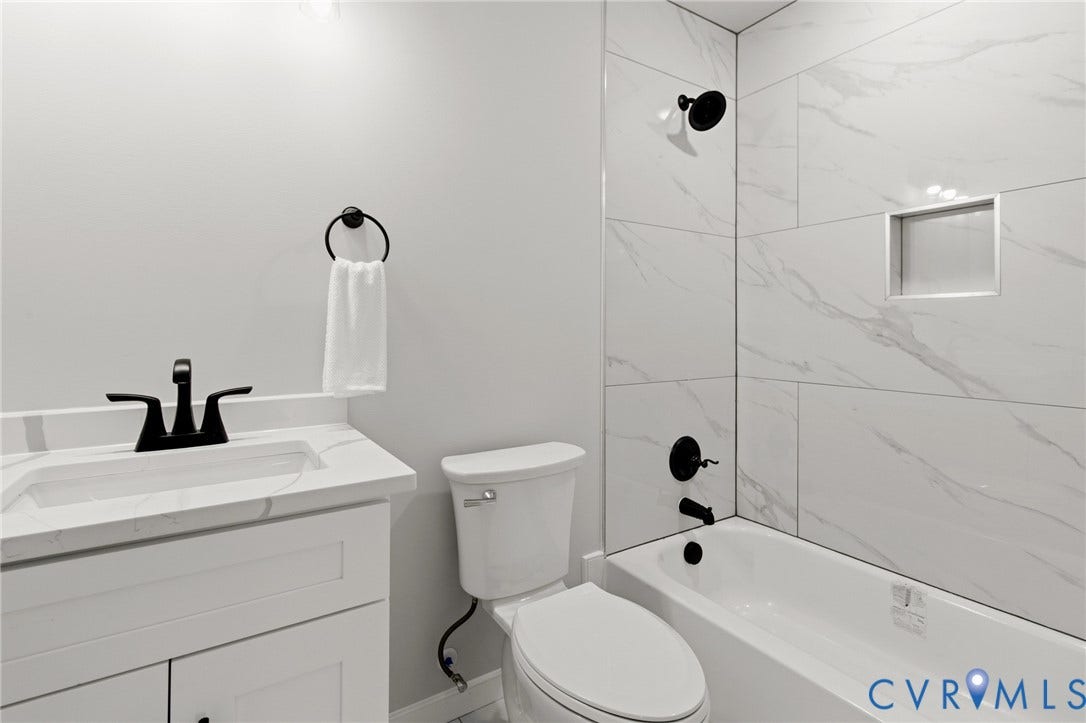 White vanity with a quartz-finish countertop and matte black faucet