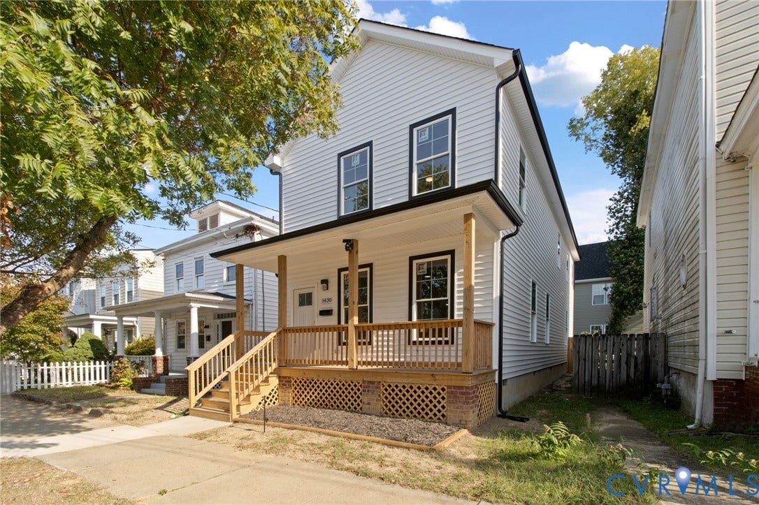 Two-story property with light-colored siding and black trim accents