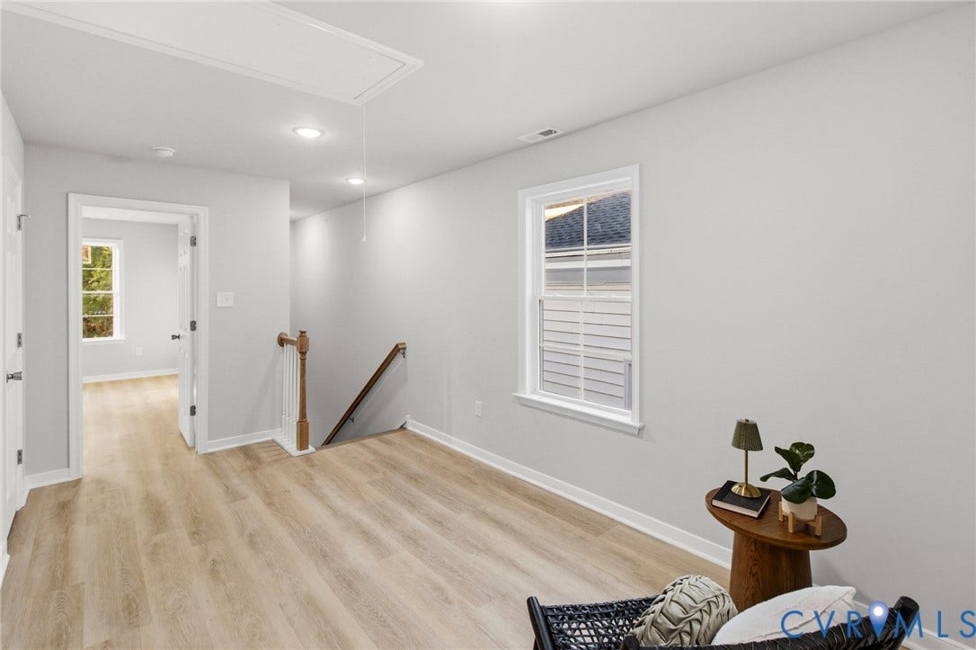 Wood-finish flooring, recessed lighting, and a white trim window
