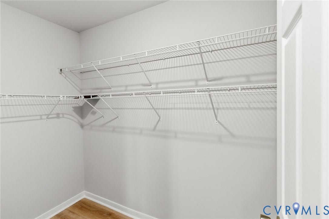 Interior closet featuring wire shelving and wood-finish flooring