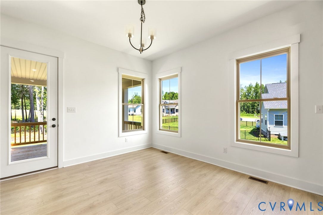 9514 Angels Share Drive, New Kent, VA 23141 Recessed lighting, wood-finish flooring, two large windows, a glass-paned door, and a multi-arm chandelier