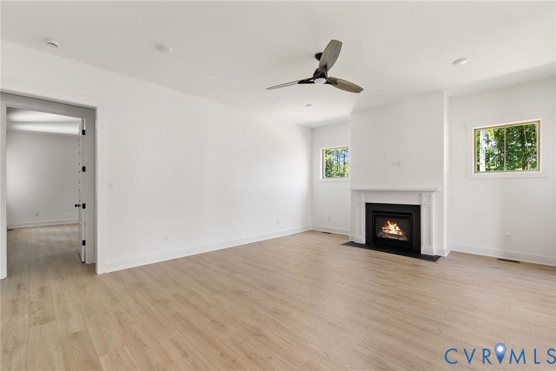 9514 Angels Share Drive, New Kent, VA 23141 Light wood-finish flooring, white walls, and a recessed fireplace with a white mantel and black surround
