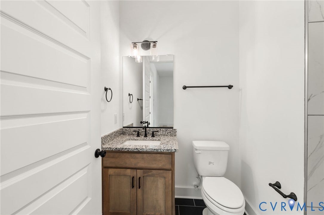 9514 Angels Share Drive, New Kent, VA 23141 Vanity with granite countertop, wood-finish cabinetry, and matte black fixtures
