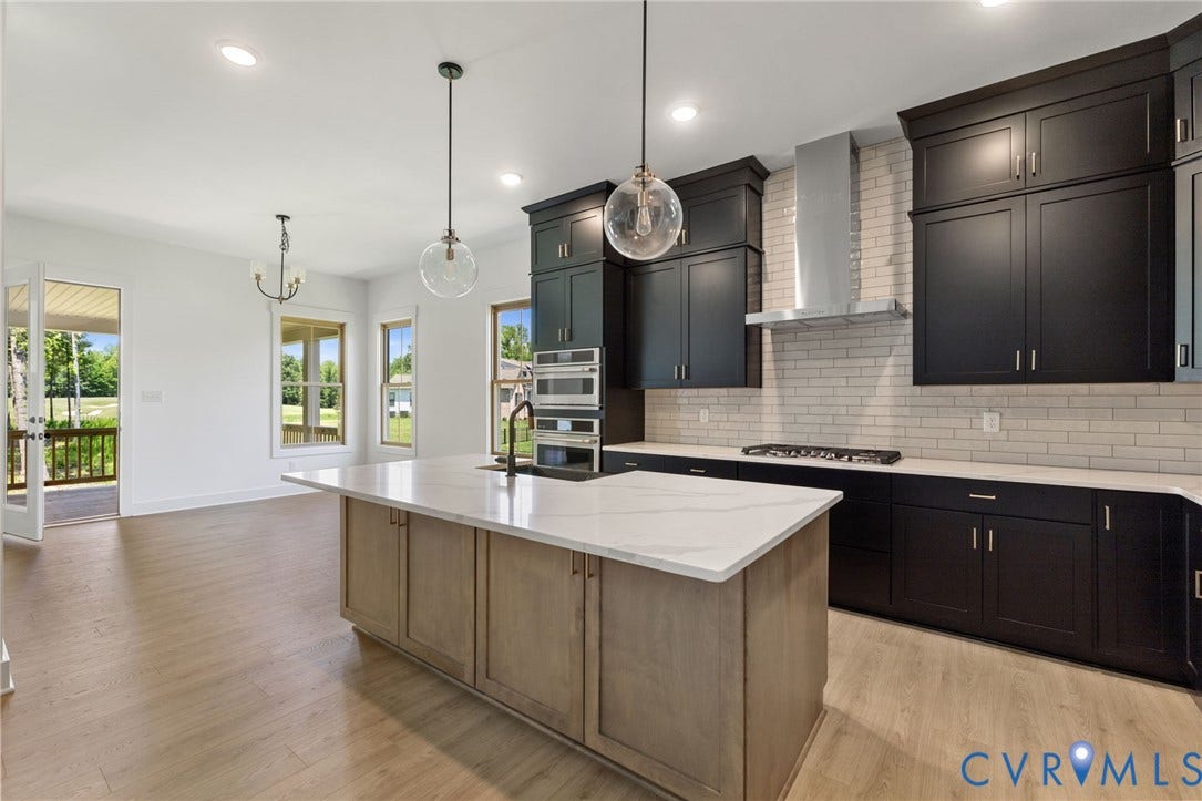 9514 Angels Share Drive, New Kent, VA 23141 Spacious kitchen featuring an island with a light wood-finish base, white countertop, and integrated sink