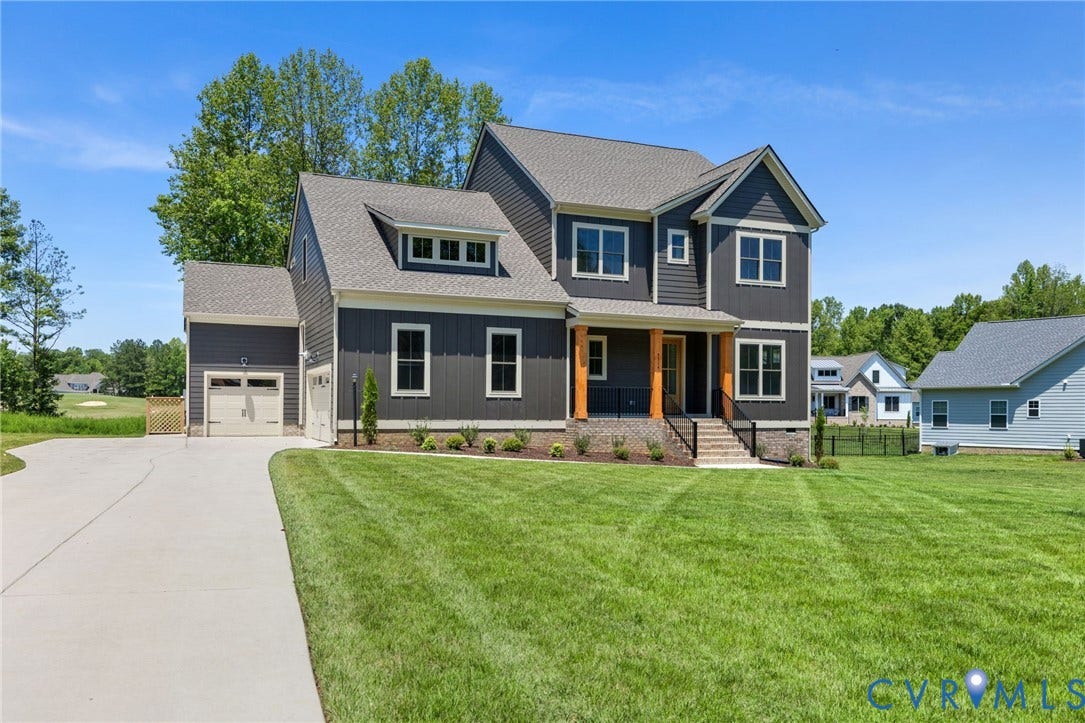 9514 Angels Share Drive, New Kent, VA 23141 Dark gray siding exterior with white trim, a covered front porch with natural wood columns, an attached two-car garage, a concrete driveway, and a sloped roof