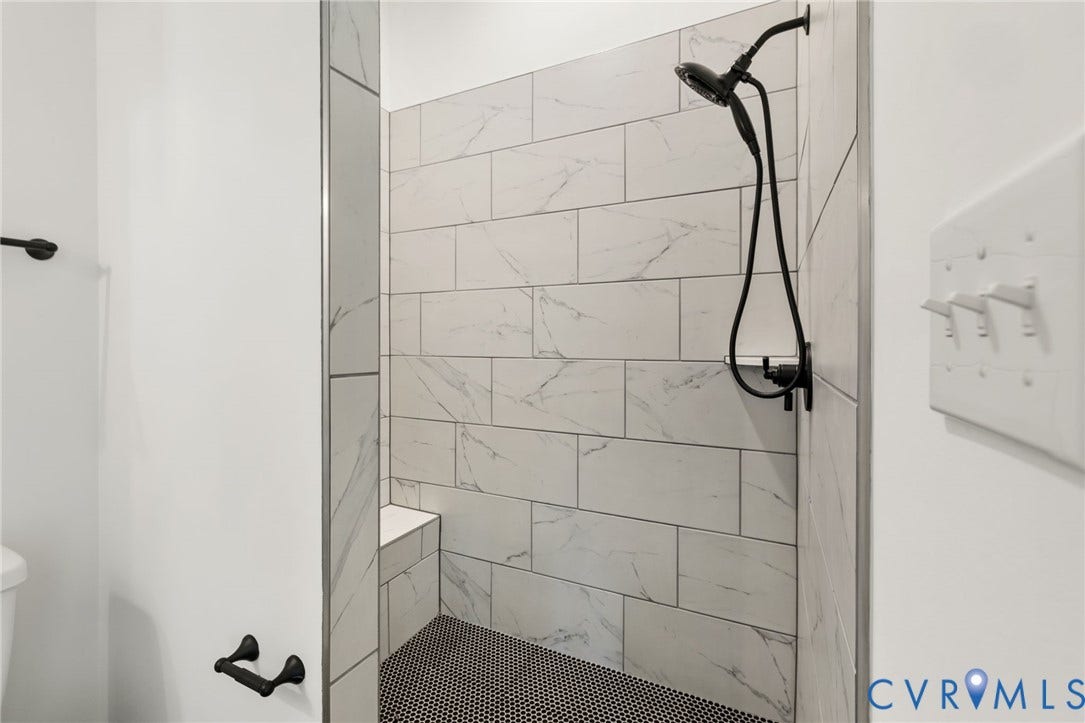 9514 Angels Share Drive, New Kent, VA 23141 Walk-in shower featuring subway-tiled walls, a built-in bench, and black penny tile flooring