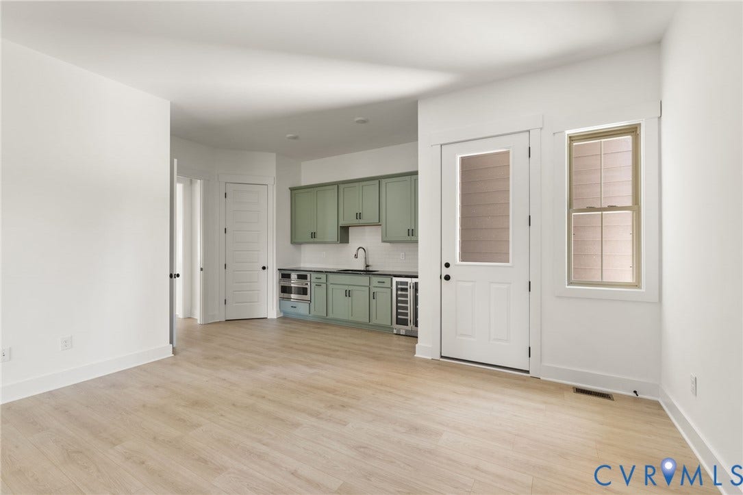 9514 Angels Share Drive, New Kent, VA 23141 Light wood-finish flooring, white walls, and a built-in wet bar with sage green cabinetry, a single basin sink, and integrated beverage refrigerators