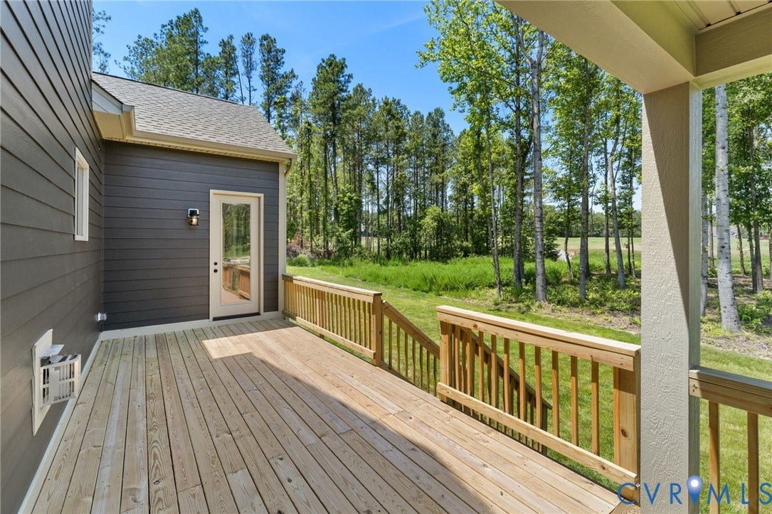 9514 Angels Share Drive, New Kent, VA 23141 Spacious wood deck with natural wood railing, complete with a glass-paneled exterior door and mounted wall light