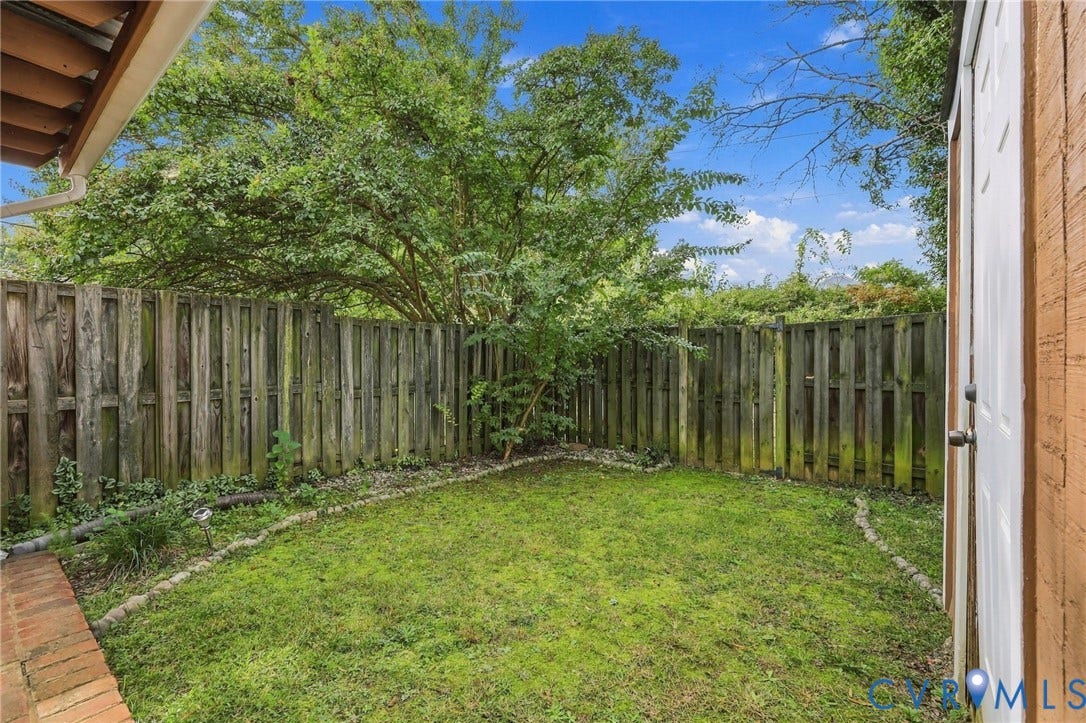 8434 Shannon Green Court, Henrico, VA 23228 Enclosed yard featuring a wood privacy fence, green lawn, and mature foliage