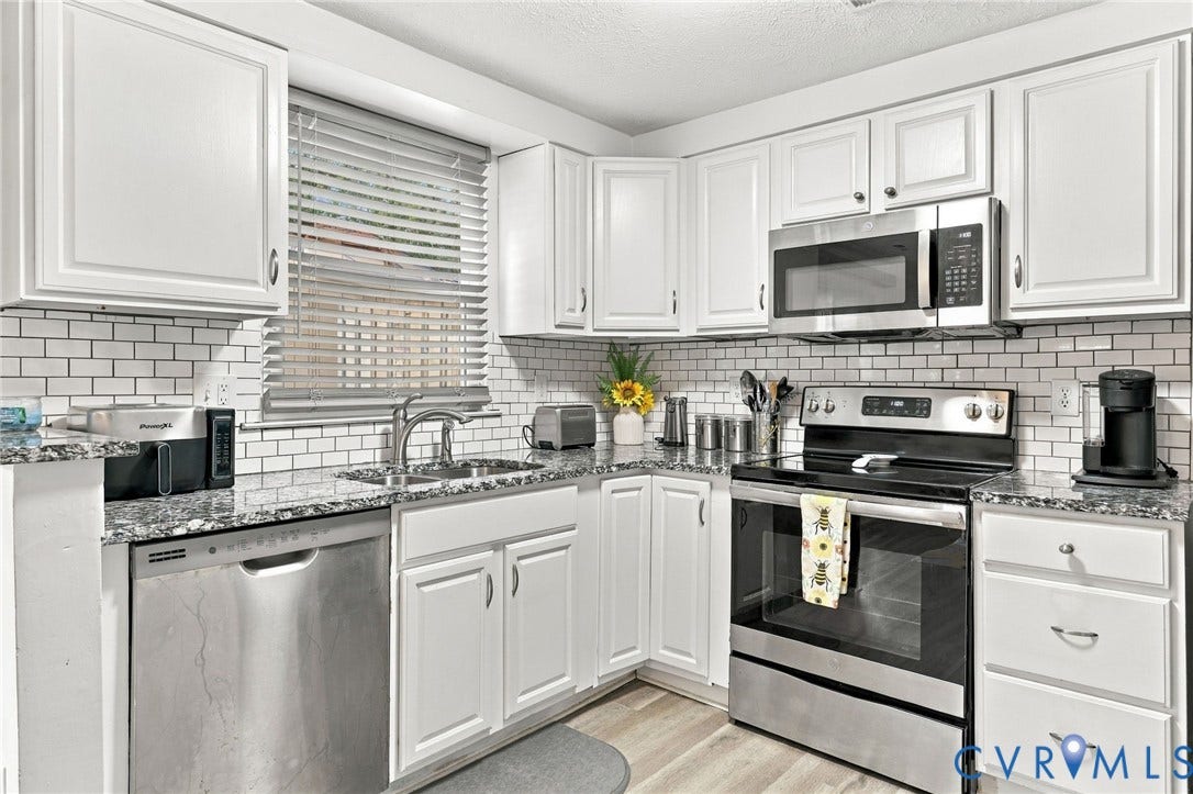 8434 Shannon Green Court, Henrico, VA 23228 White cabinetry, subway tile backsplash, stainless steel appliances, granite-style countertops, and wood-finish flooring
