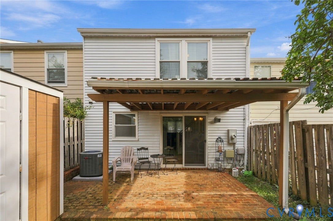 8434 Shannon Green Court, Henrico, VA 23228 Rear exterior with white horizontal siding and a brick-finish patio
