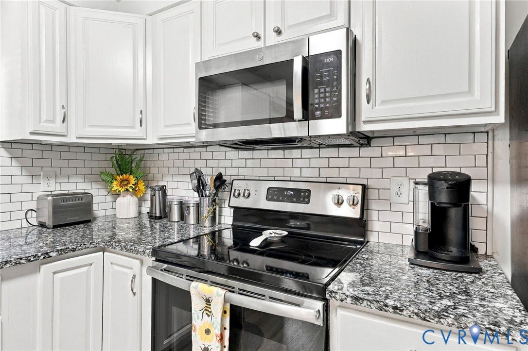 8434 Shannon Green Court, Henrico, VA 23228 White cabinetry, subway tile backsplash, stainless steel microwave, black electric range, and speckled countertops