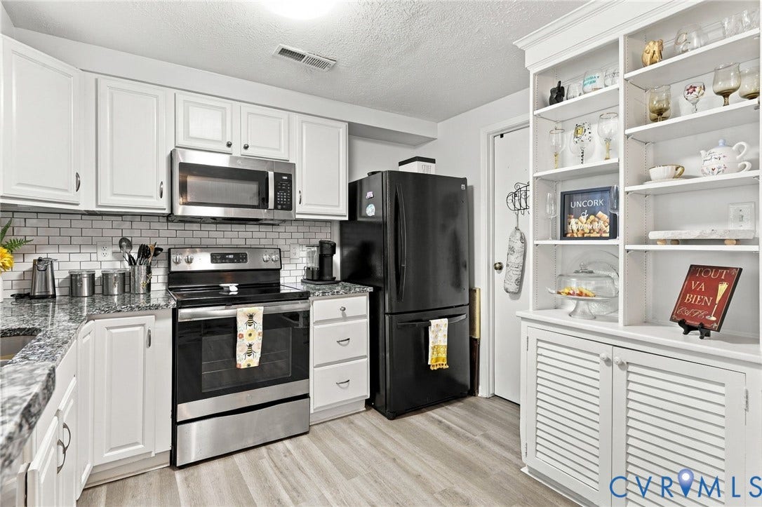 8434 Shannon Green Court, Henrico, VA 23228 Updated kitchen featuring white cabinetry, stainless steel appliances, a subway tile backsplash, granite-style countertops, and wood-finish flooring