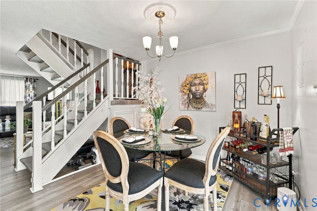 8434 Shannon Green Court, Henrico, VA 23228 Hard surface flooring, staircase with wood balusters, crown molding, and a built-in chandelier