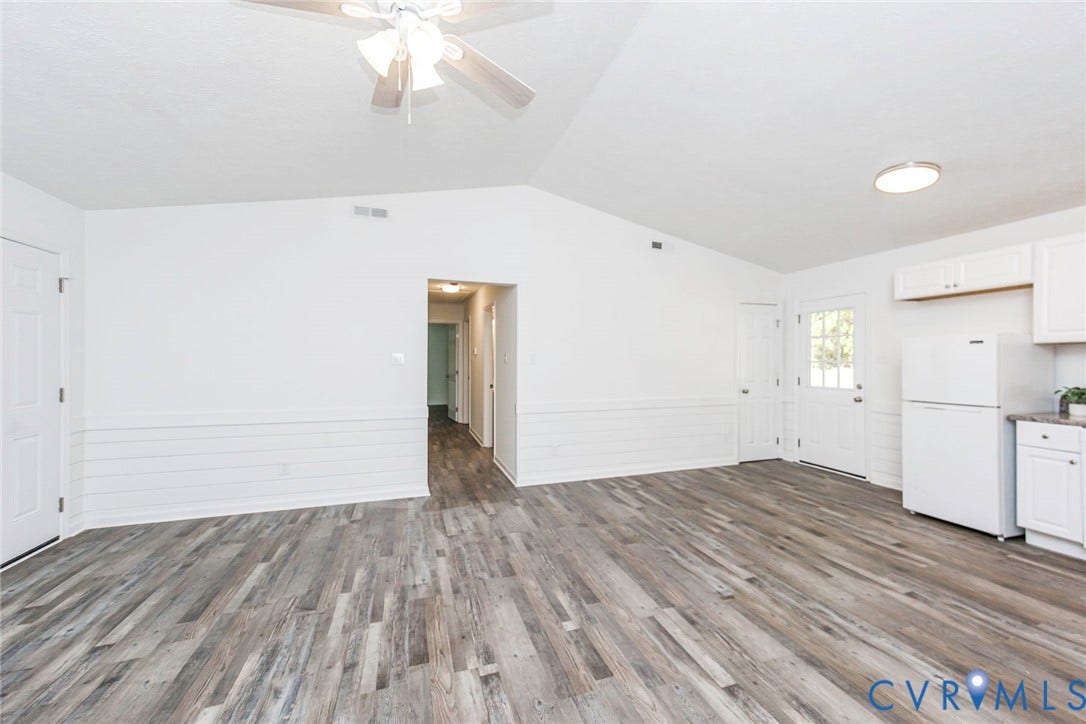 21108 Matoaca Road, Chesterfield, VA 23803 Vaulted ceiling with a ceiling fan, wood-finish flooring, white shiplap wall accent, white cabinetry, and white appliances