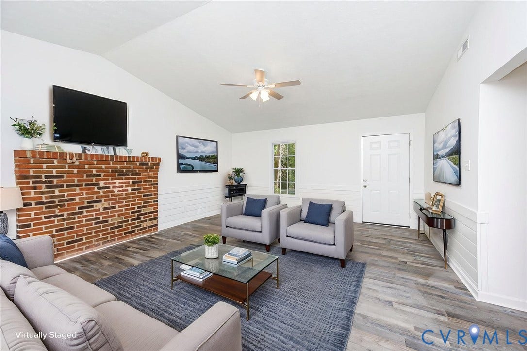 21108 Matoaca Road, Chesterfield, VA 23803 Vaulted ceiling with a ceiling fan, brick fireplace, wood-finish flooring, and white paneled walls