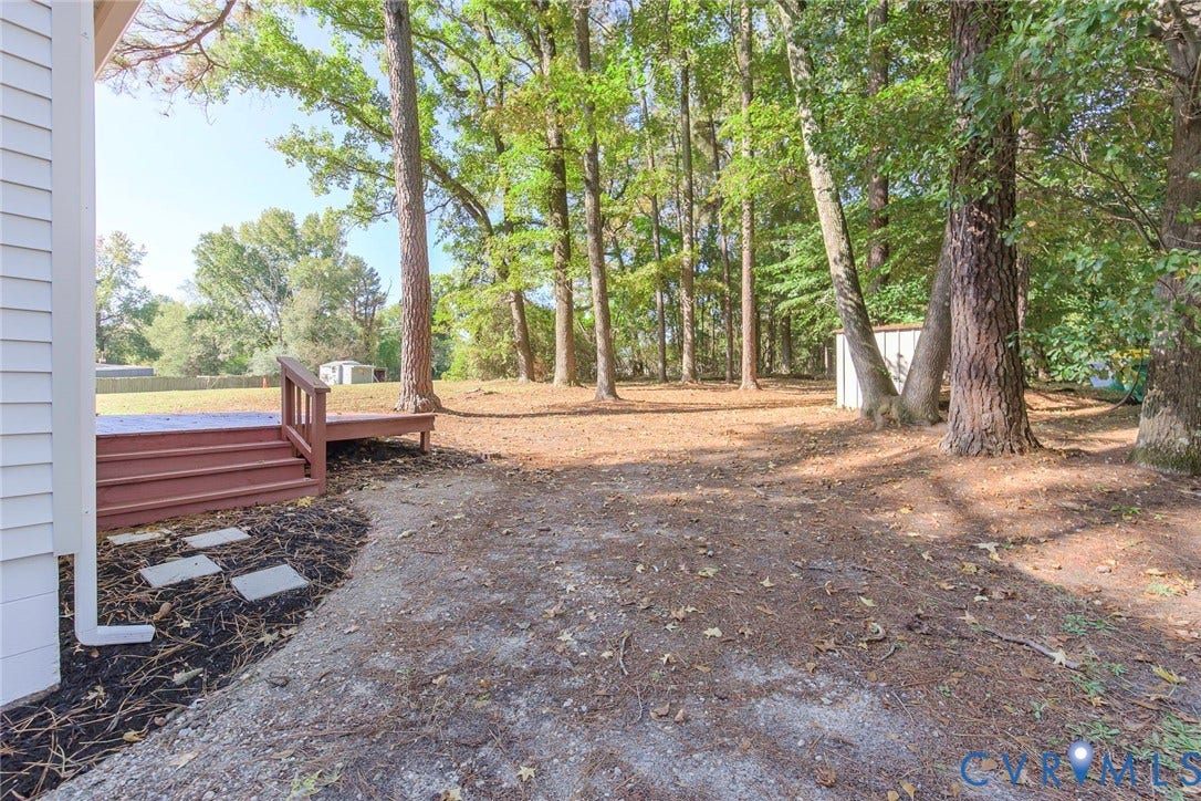 21108 Matoaca Road, Chesterfield, VA 23803 Expansive yard featuring mature trees, a wooden deck, and a detached shed