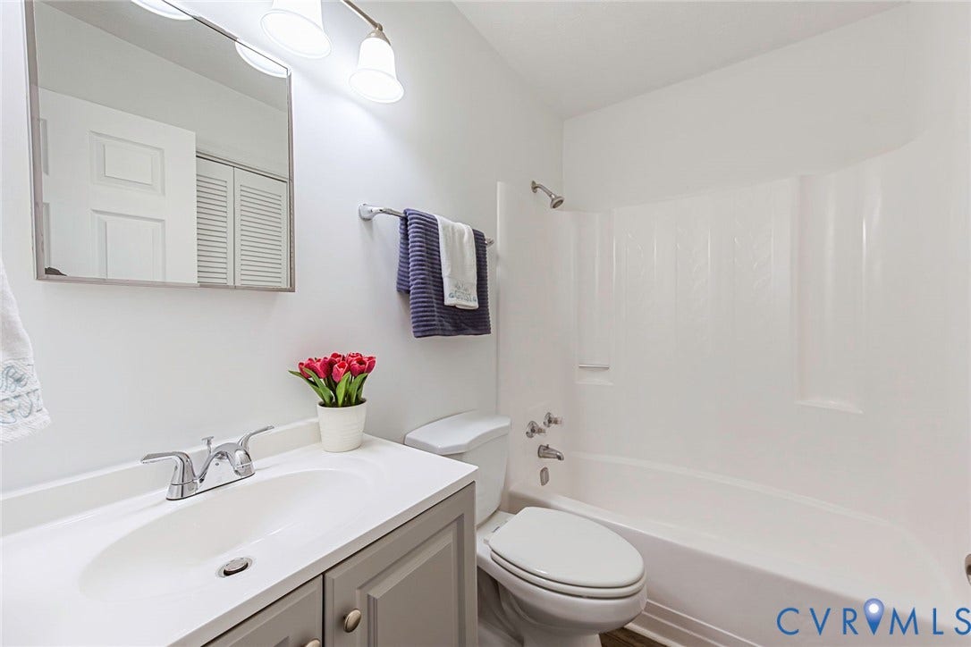 21108 Matoaca Road, Chesterfield, VA 23803 White wall finish, gray vanity with silver hardware, white countertop with integrated sink, chrome faucet, white tub and shower surround