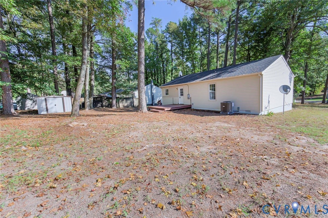 21108 Matoaca Road, Chesterfield, VA 23803 Spacious exterior featuring a light-colored siding, a dark shingle roof, a ground-level deck, and a white storage shed