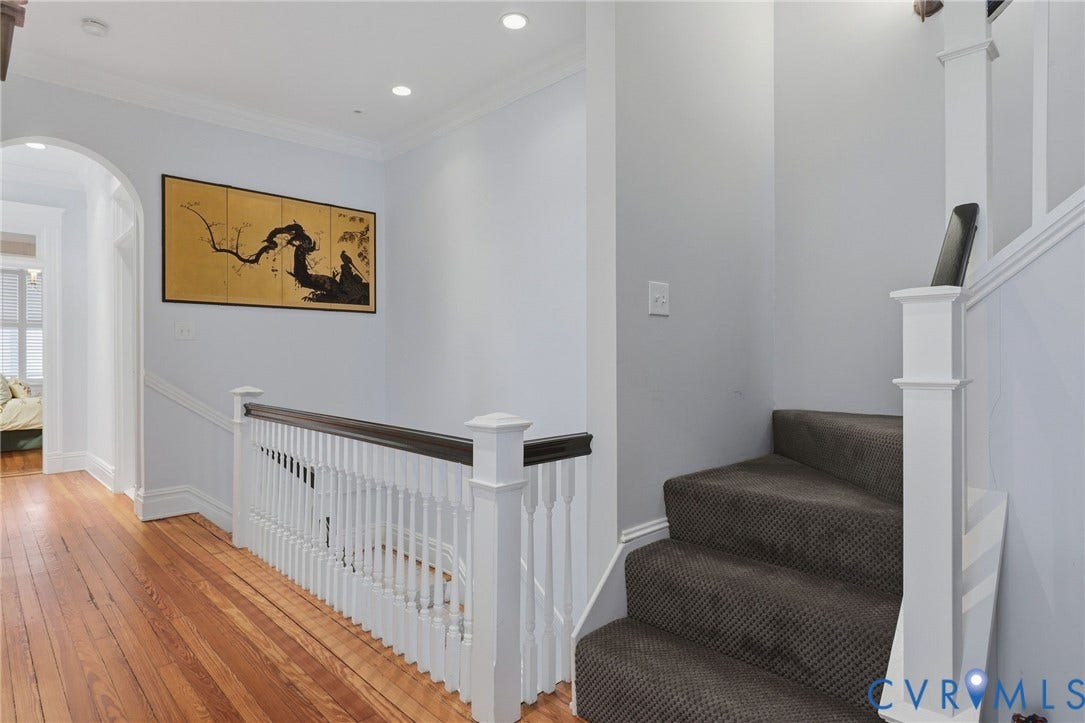 2624 Park Avenue, The Fan District, Richmond, VA 23220 Hardwood flooring, painted white balusters, black painted handrail, recessed lighting, and arched hall doorway