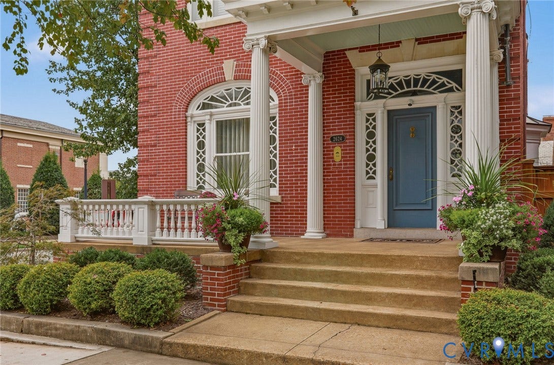 2624 Park Avenue, The Fan District, Richmond, VA 23220 Brick exterior featuring a portico with fluted columns, a blue entry door with a transom, and an arched window