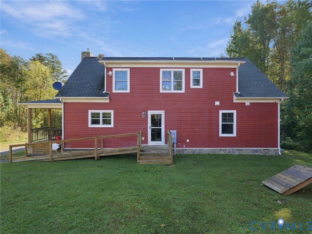 16233 Pleasant Mill Road, Montpelier, VA 23192 Two-story exterior featuring red horizontal siding, a stone veneer foundation, a multi-gabled shingle roof, and an attached wooden ramp