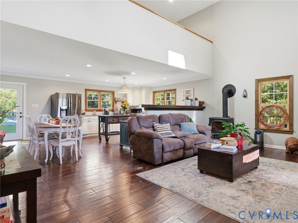 16233 Pleasant Mill Road, Montpelier, VA 23192 Vaulted ceilings, dark wood-finish flooring, recessed lighting, and a cast-iron wood-burning stove with a chimney pipe