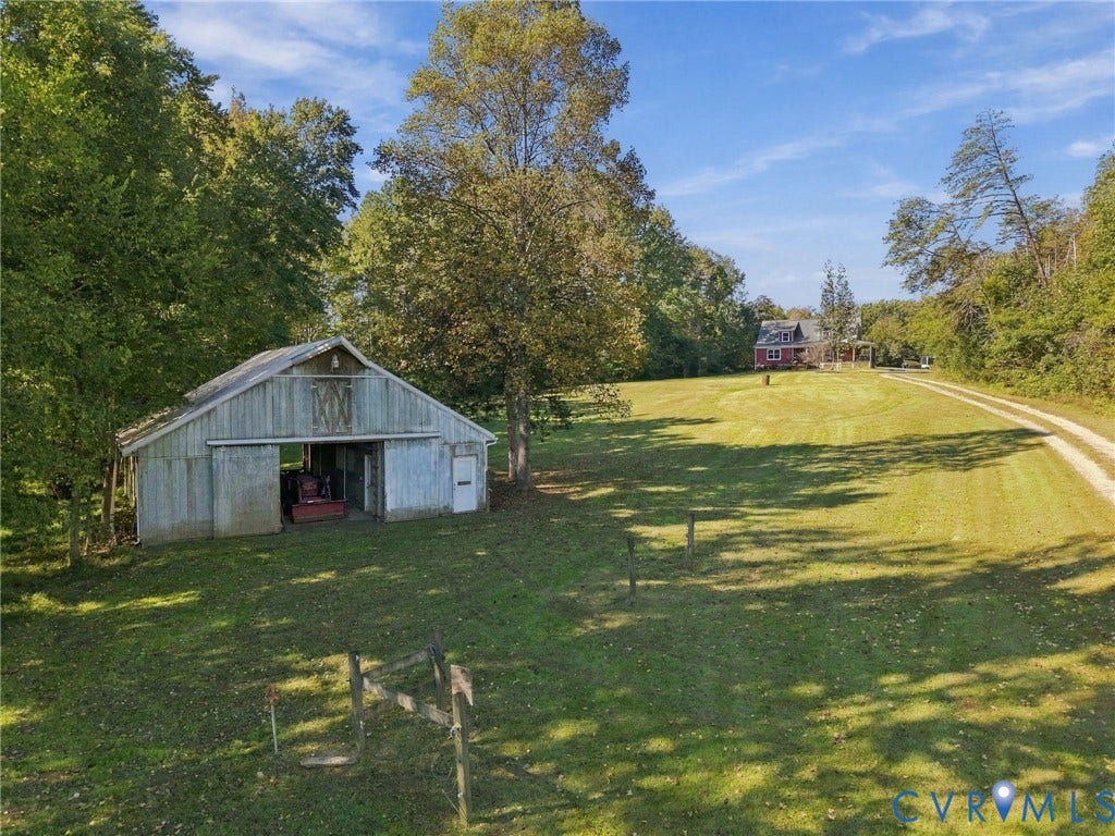 16233 Pleasant Mill Road, Montpelier, VA 23192 Expansive acreage featuring a wooden barn, gravel driveway, open lawn, and mature trees