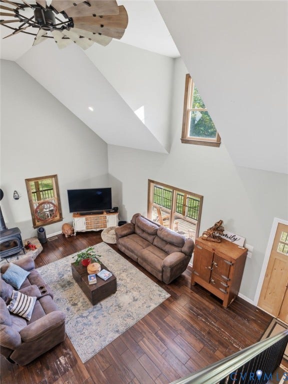 16233 Pleasant Mill Road, Montpelier, VA 23192 Vaulted ceiling with an industrial-style windmill ceiling fan, wood-finish flooring, wood-burning stove on a stone hearth, and multiple windows