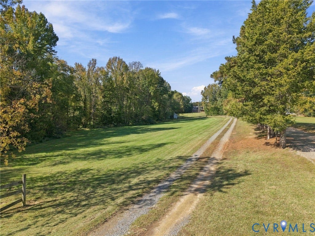 16233 Pleasant Mill Road, Montpelier, VA 23192 Expansive acreage featuring a manicured lawn, tree-lined perimeter, and a gravel drive