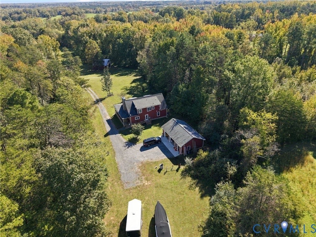 16233 Pleasant Mill Road, Montpelier, VA 23192 Expansive wooded acreage featuring a two-story residence, a detached garage with multiple bays, and an extensive gravel driveway