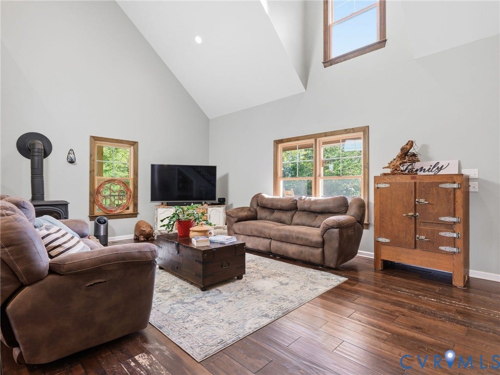 16233 Pleasant Mill Road, Montpelier, VA 23192 Vaulted ceilings, wood-finish flooring, multi-pane windows with natural wood trim, and a cast-iron wood stove