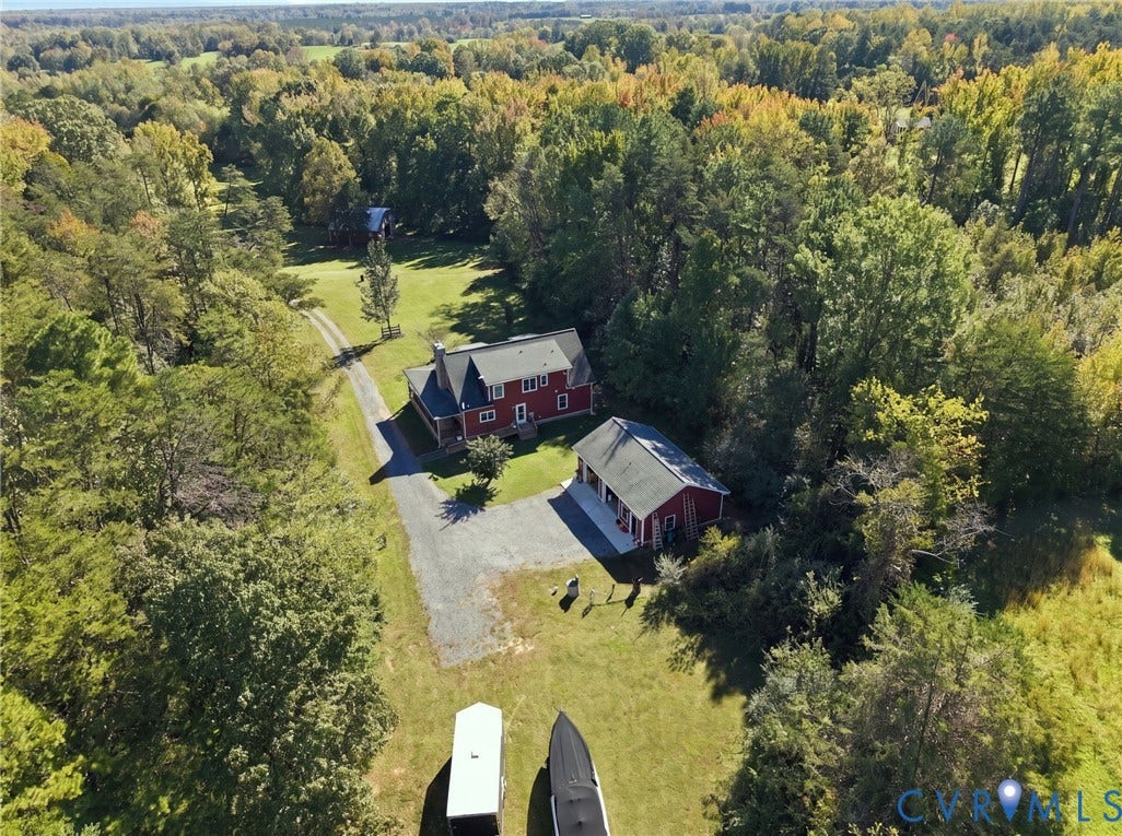 16233 Pleasant Mill Road, Montpelier, VA 23192 Expansive rural property featuring a multi-story residence, a detached garage structure, a gravel driveway, and mature perimeter woodland