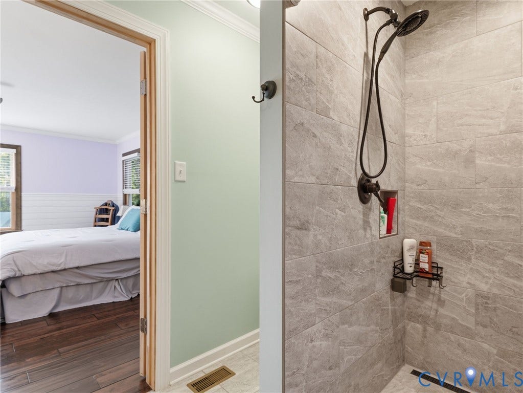 16233 Pleasant Mill Road, Montpelier, VA 23192 Walk-in shower featuring large-format grey stone-finish tile, oil-rubbed bronze shower fixtures, and a recessed wall niche