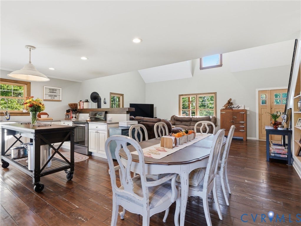 16233 Pleasant Mill Road, Montpelier, VA 23192 Open concept kitchen and dining area featuring wood-finish flooring, vaulted ceilings, recessed lighting, a kitchen island with industrial casters, and wood-framed windows